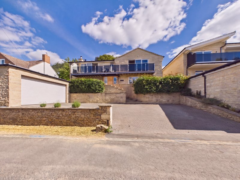 Modern brick house with driveway, garage, and stone retaining wall