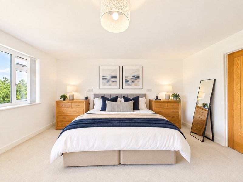 Bright modern bedroom with double bed, wooden nightstands, framed artwork and pendant light fixture