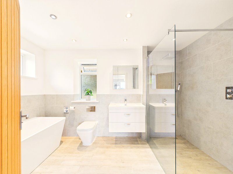 Modern bathroom with freestanding tub, toilet, vanity, and walk-in shower with glass enclosure