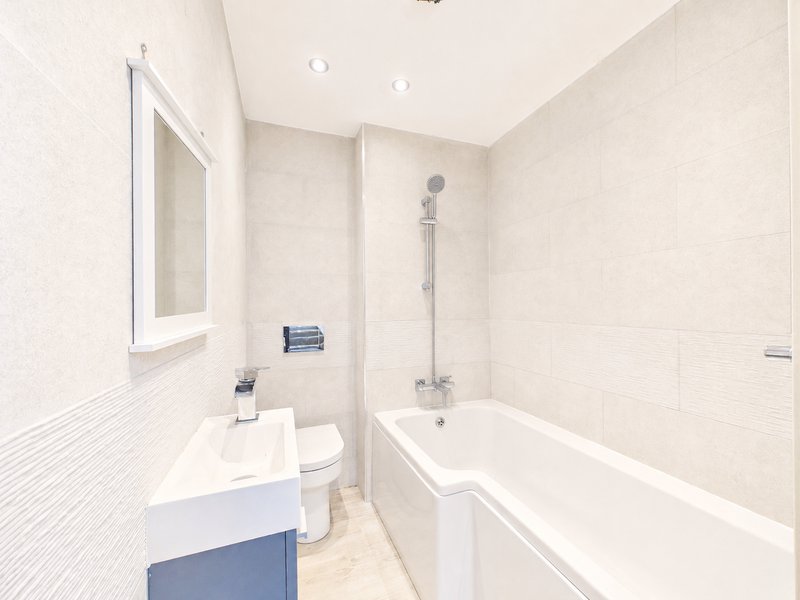Modern bathroom with white toilet, sink vanity, bathtub and shower enclosure