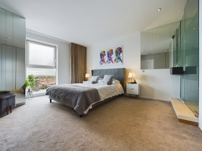 Modern bedroom with double bed, ensuite bathroom, large window and contemporary artwork