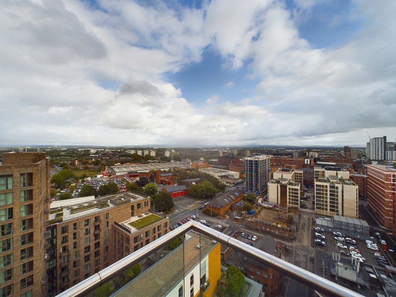 Aerial view of urban cityscape with residential buildings, streets and mountains in distance