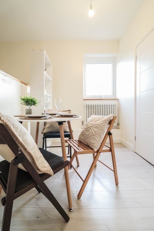Bright modern bedroom workspace with wooden desk, chair, and natural light from window