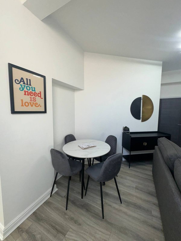 Compact dining area with small round table, gray chairs, and wall art