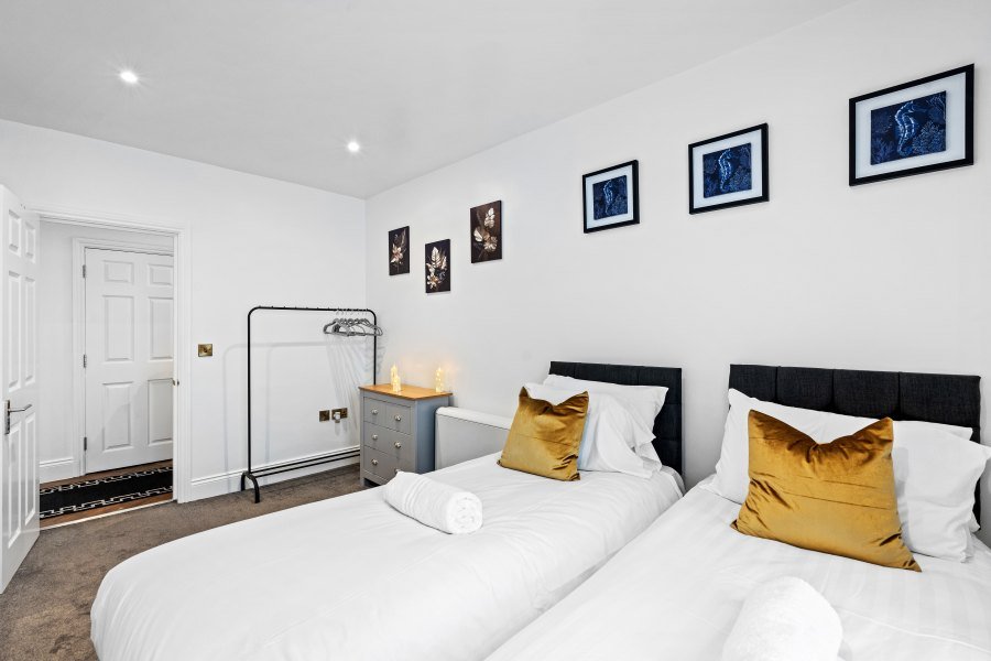 Twin bedroom setup with comfortable beds, fresh linen and flexible sleeping arrangements for working guests.