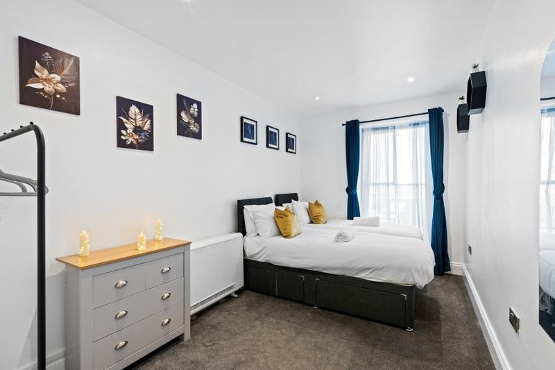 Comfortable second bedroom with flexible king or twin bed configuration, ideal for colleagues sharing accommodation.