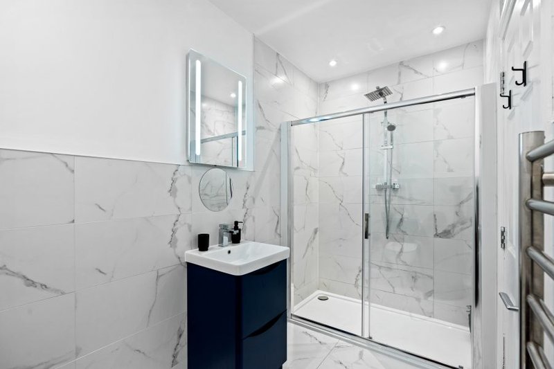 Modern en-suite bathroom with walk-in shower, providing added convenience for teams sharing the apartment.