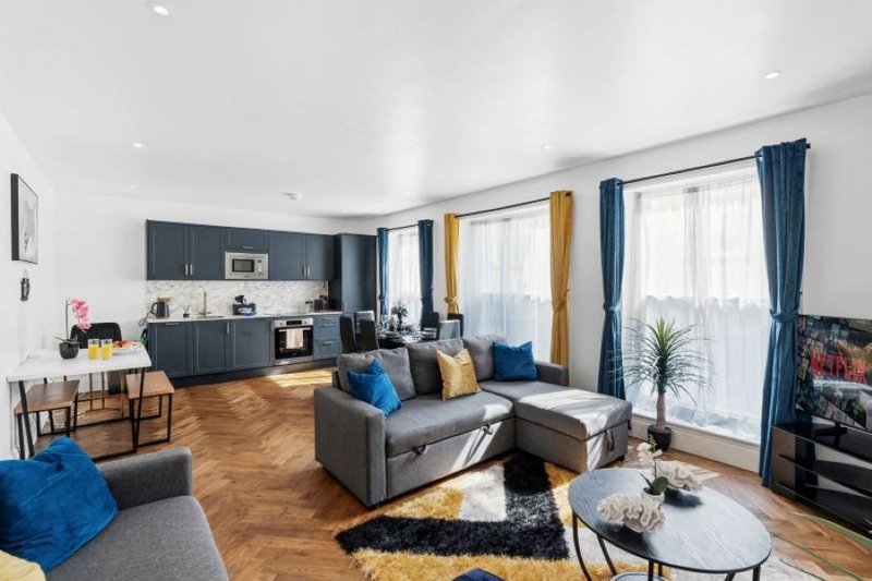 Spacious open-plan living and kitchen area with comfortable seating, dining space and plenty of natural light.