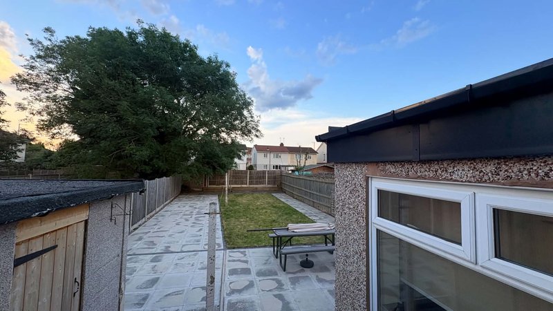 Rear garden with paved patio, lawn, fencing and modern single-story extension