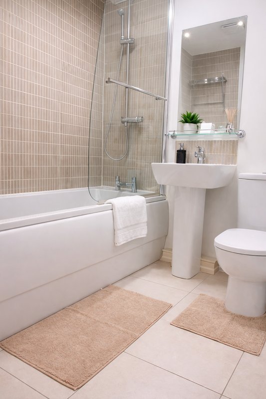 Modern bathroom with bathtub, shower, pedestal sink, toilet and tiled walls