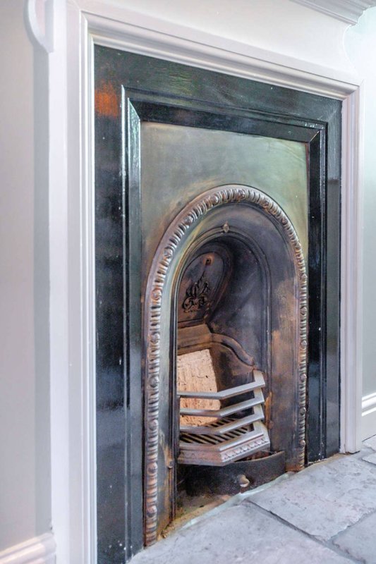 Decorative fireplace insert with ornate brass surround and arched opening