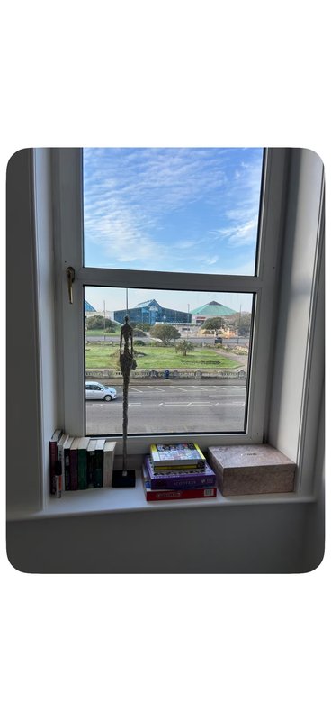 Window view of countryside landscape with books and decorative items on sill