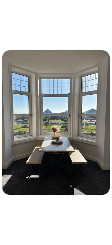 Bay window seating area with table, mountain views through multi-pane windows