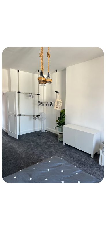 Modern bathroom with walk-in shower enclosure, pendant lighting, white vanity and dark tile flooring