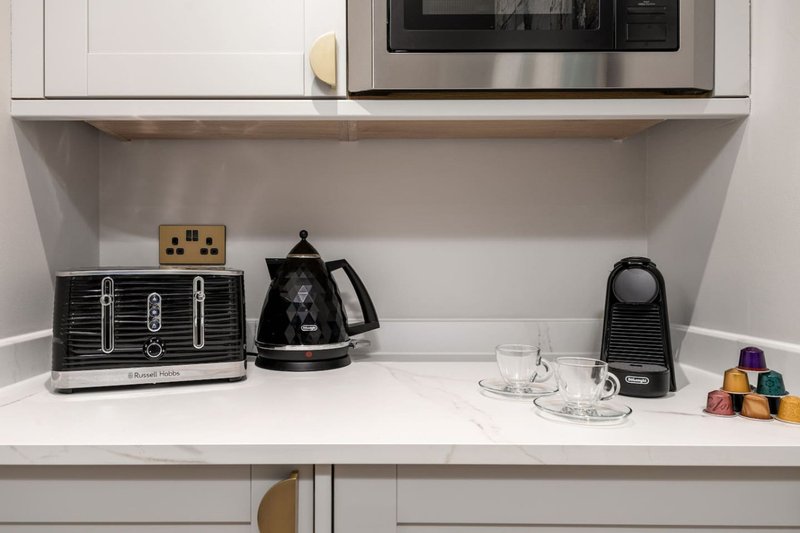 Modern kitchen shelf with toaster, kettle, microwave and decorative items