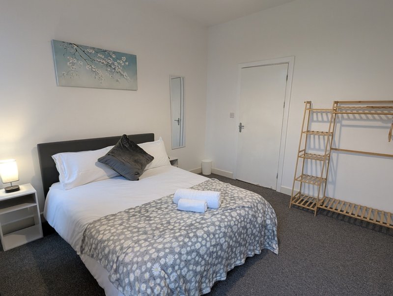 A generous bedroom with a comfortable double bed, fresh bedding, bedside lighting and ample space for storing and hanging clothes, giving contractors plenty of room to settle in during longer stays