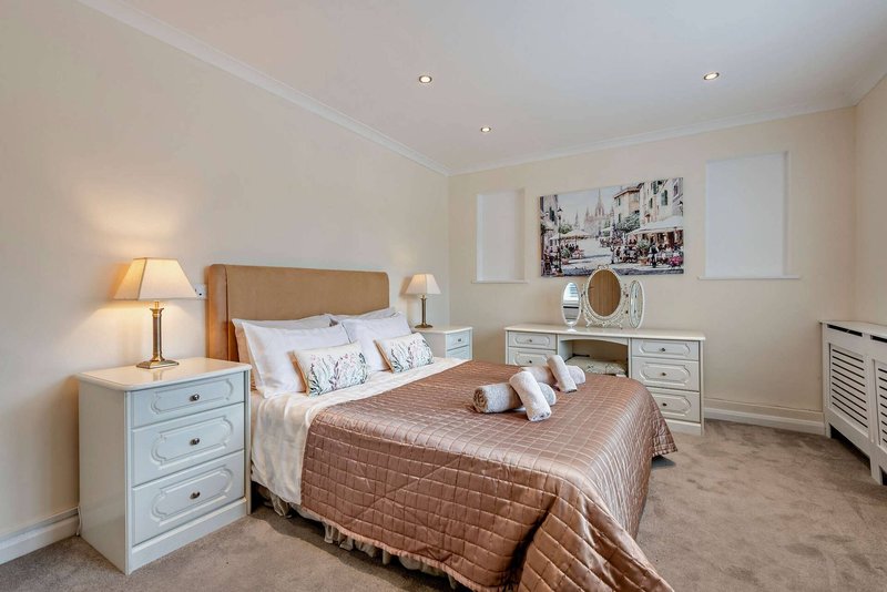 Spacious bedroom with double bed, bedside tables, dressing table and warm lighting