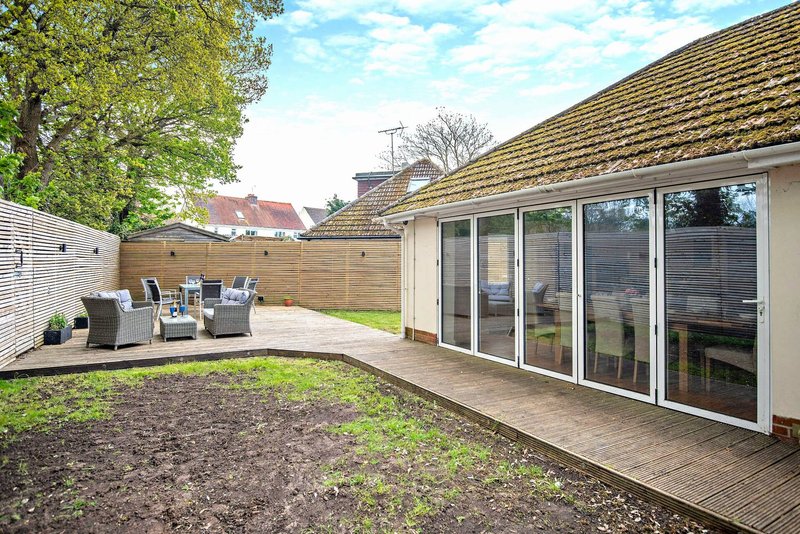 Modern garden with patio, seating area, and large sliding glass doors to house