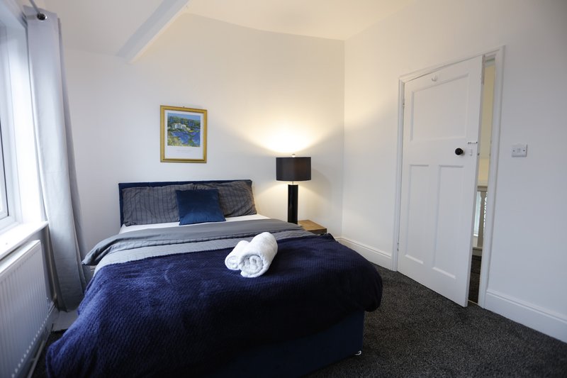 Cosy double bedroom with a comfortable bed, soft bedding, and a window providing natural light. A simple, well-presented space offering contractors a comfortable place to rest and recharge.