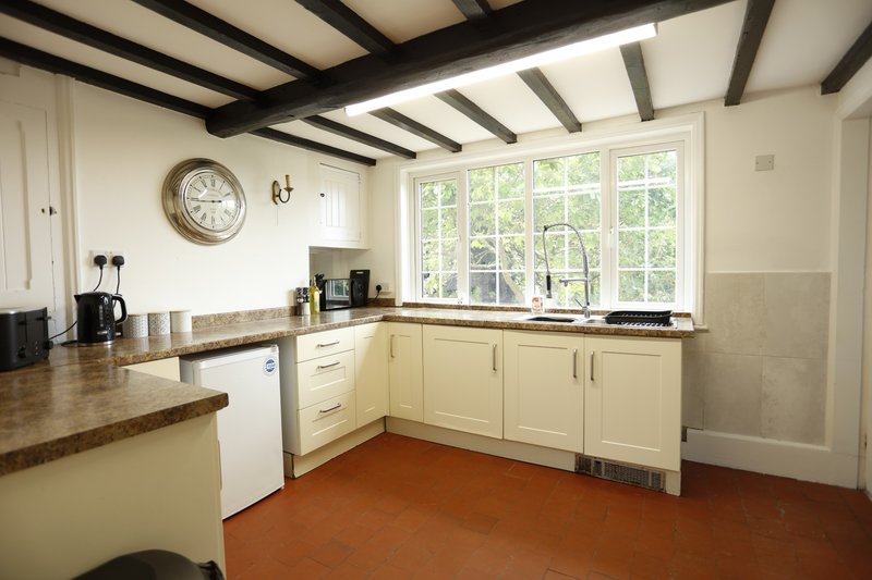 Well-equipped, spacious kitchen with ample worktop and cupboard space, a large window for plenty of natural light, and essential appliances. A practical setup for groups to prepare meals.