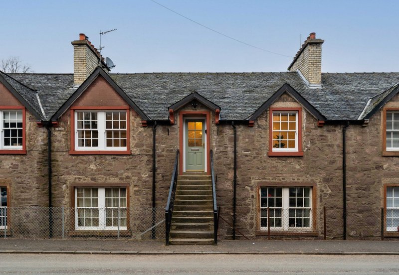 Stone terraced house with red sandstone accents, multiple sash windows and central entrance stairs