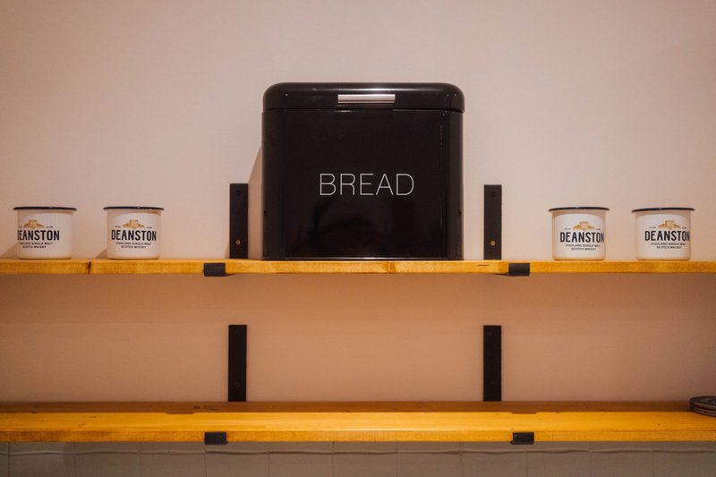 Kitchen shelf with black bread bin and branded storage jars