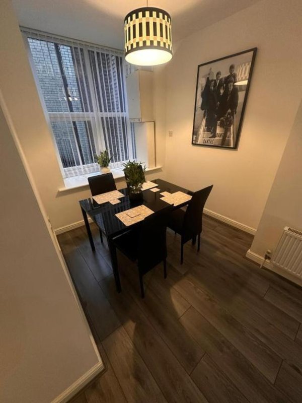 Dining room with black table, chairs, pendant light fixture and framed wall art